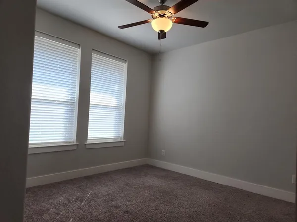an empty room with a window and a fan