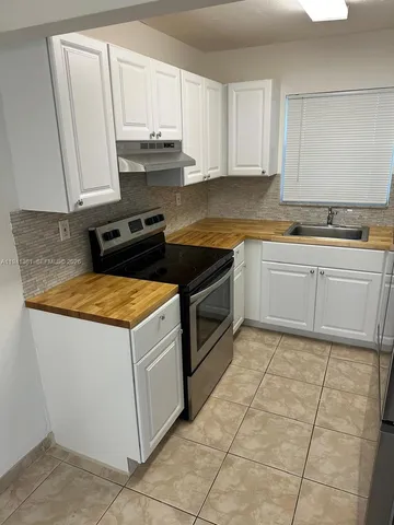 a kitchen with a sink stove and cabinets