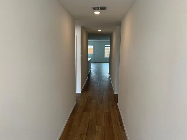 a view of a hallway with wooden floor and staircase