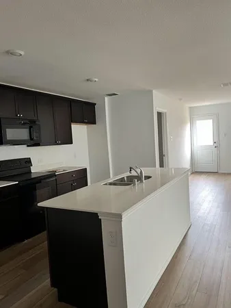 a kitchen with stainless steel appliances kitchen island granite countertop a stove a sink and a refrigerator