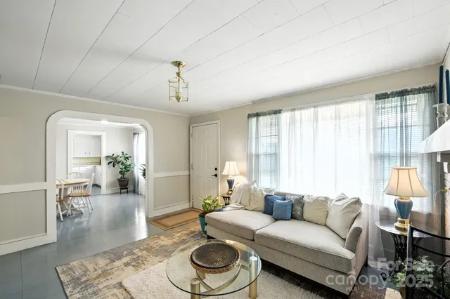 a dining room with furniture potted plants and wooden floor