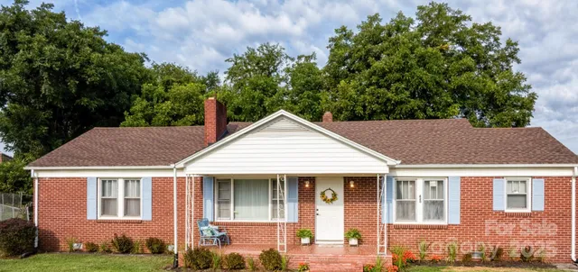 a view of a house with brick walls and a yard with potted plants