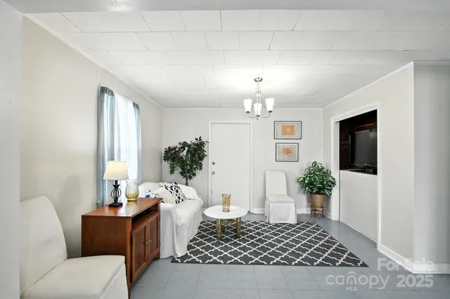 a living room with furniture and a chandelier