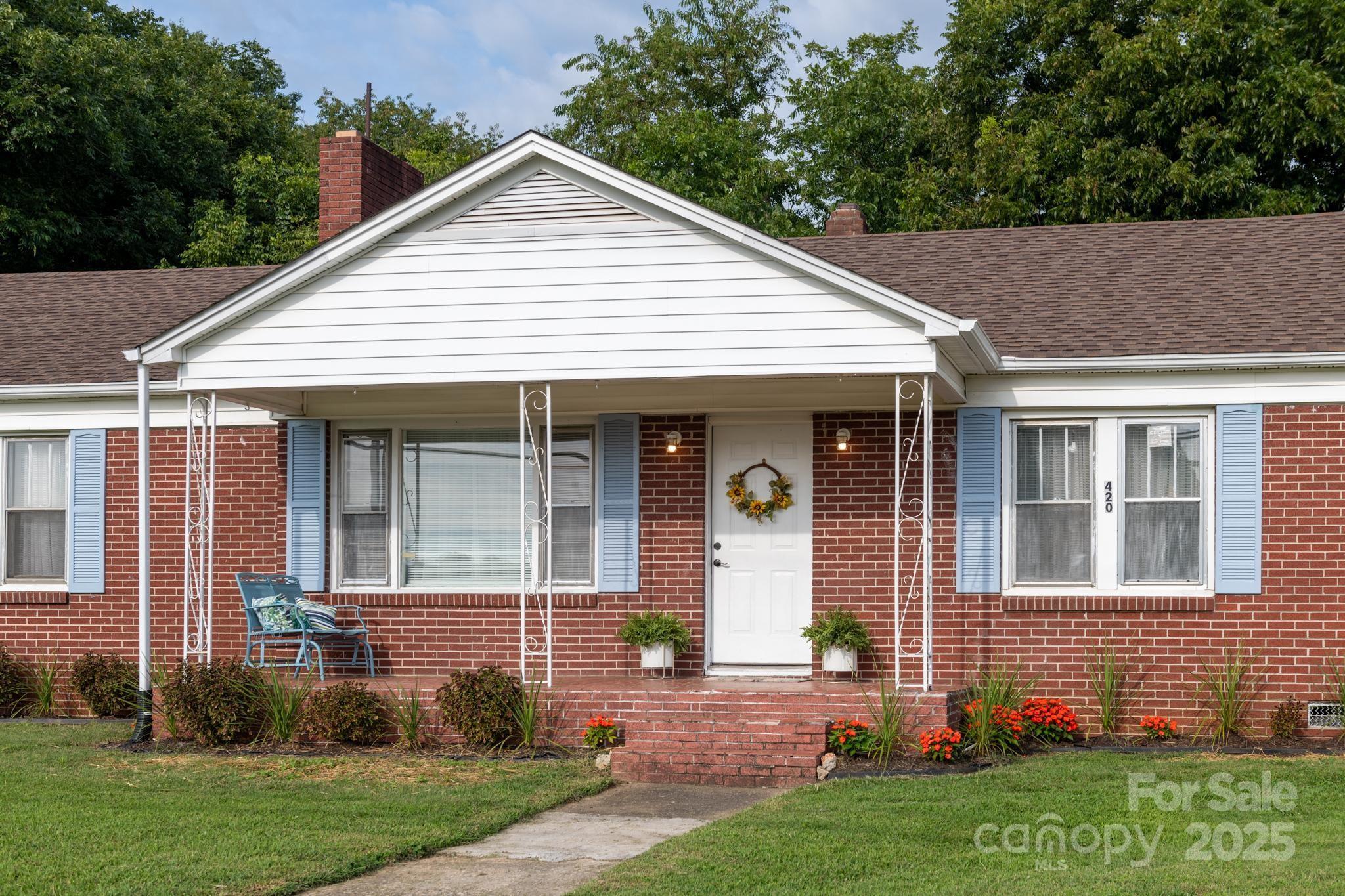 420 Virginia Street Southwest Lenoir, NC 28645 - Photo 3 of 36 a view of a house with brick walls and a yard with potted plants