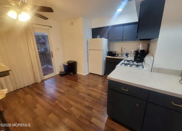 a living room with furniture a flat screen tv and a wooden floor