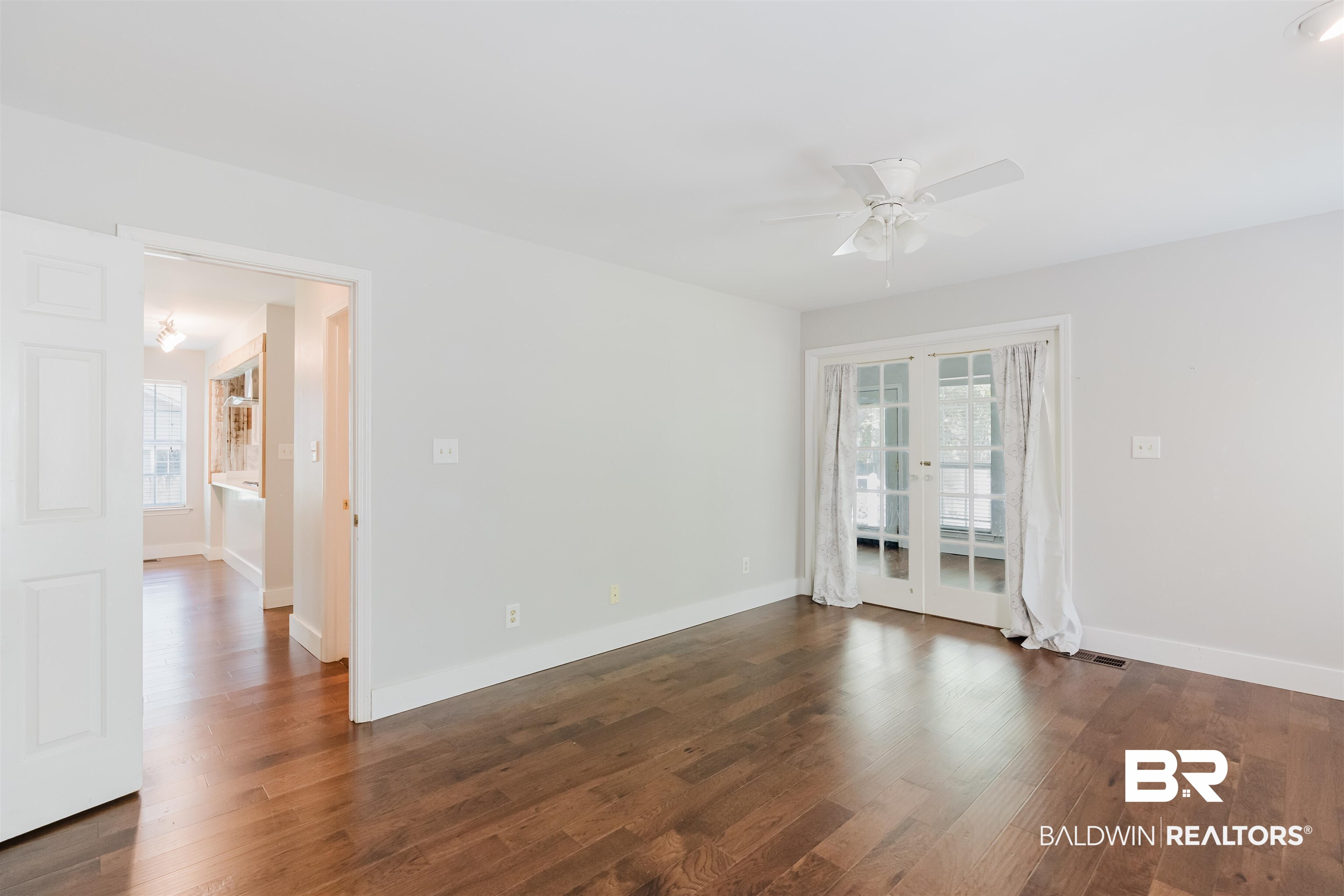 20460 Bishop Road Fairhope, AL 36532 - Photo 29 of 41 Spare room featuring ceiling fan, dark wood-style floors, baseboards, and french doors