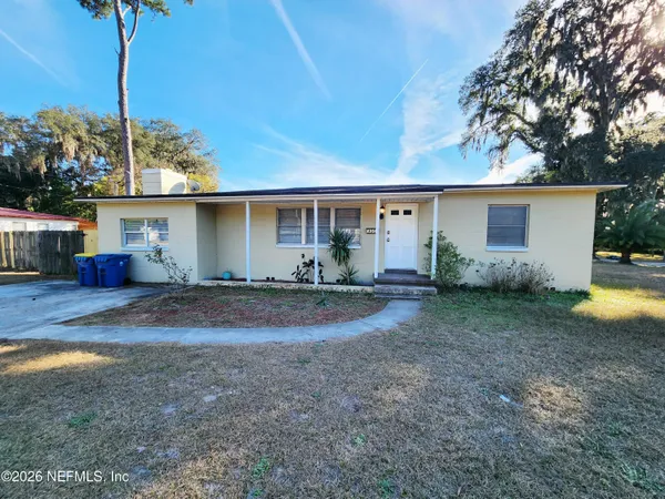 a view of a house with backyard and plants