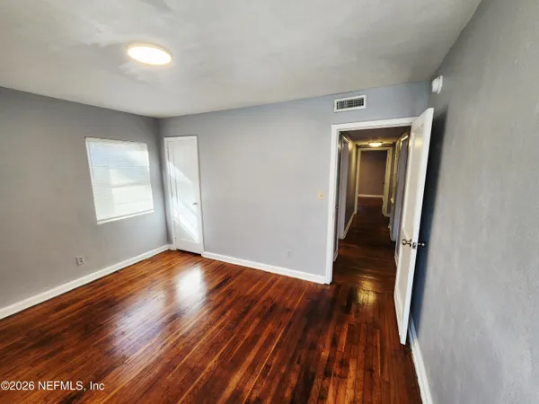 wooden floor in an empty room with a window