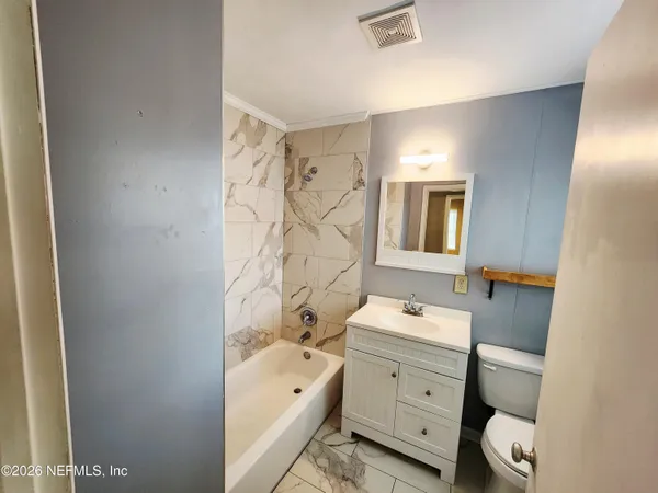 a bathroom with a sink toilet tub and shower