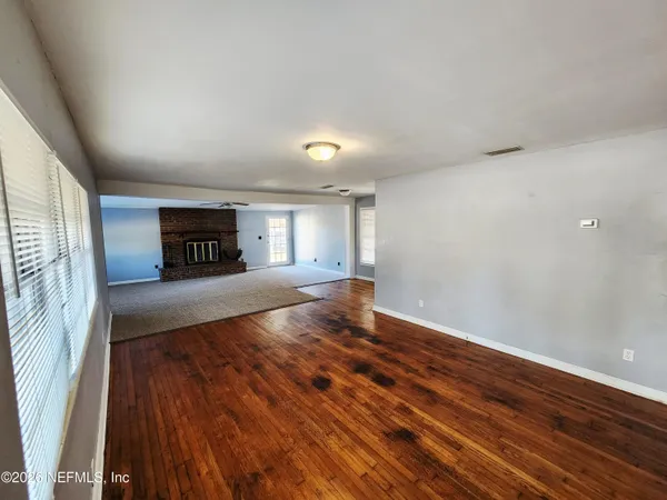 a view of a room with wooden floor and a window