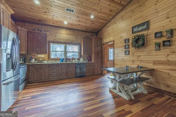 a kitchen with granite countertop a stove dining table chairs and granite counter tops