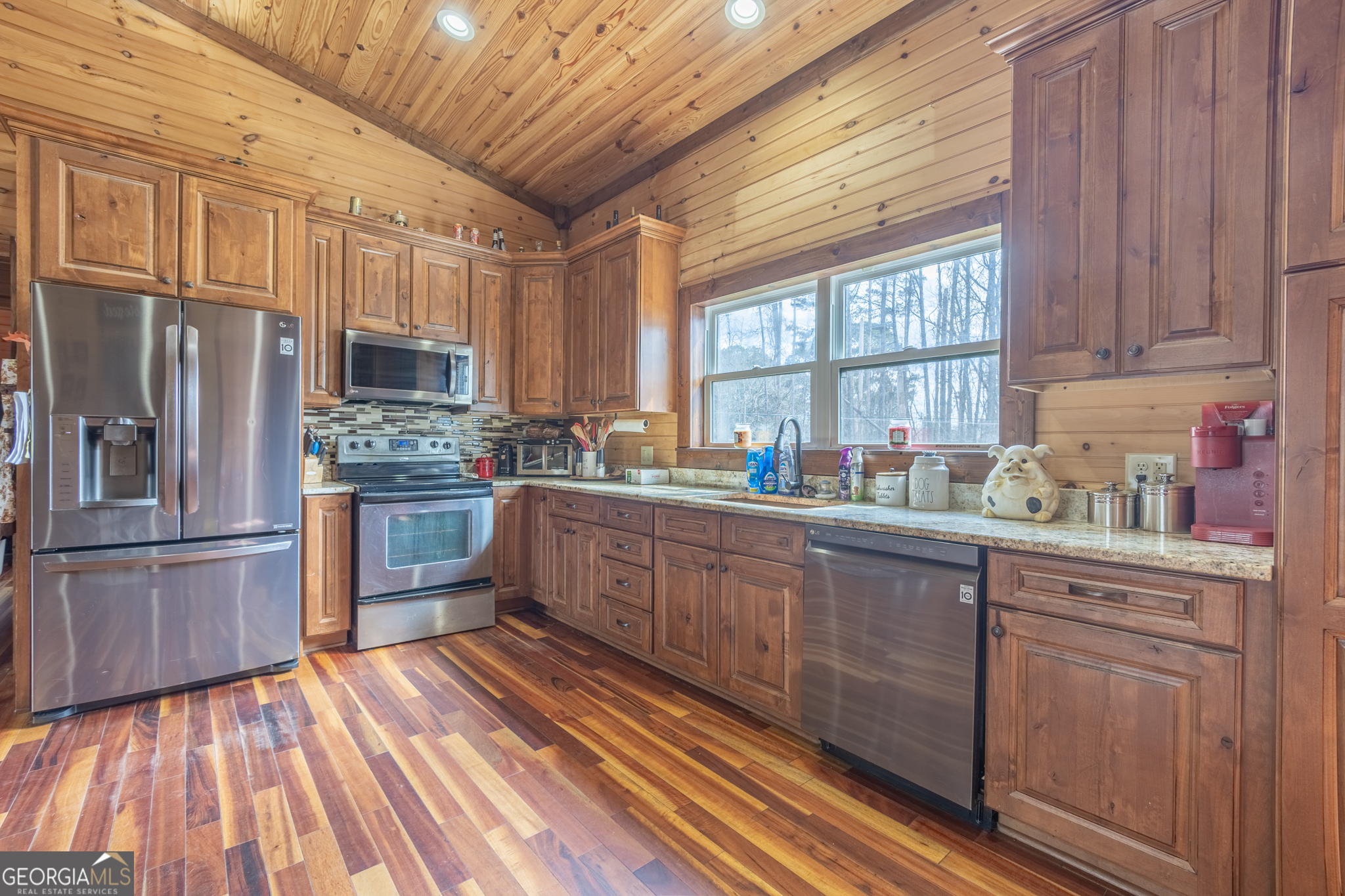 45 J J Davis Road Tallapoosa, GA 30176 - Photo 6 of 24 a kitchen with stainless steel appliances granite countertop a refrigerator a sink dishwasher a stove and white countertops with wooden floor