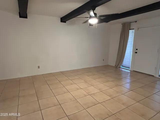 an empty room with a ceiling fan and window