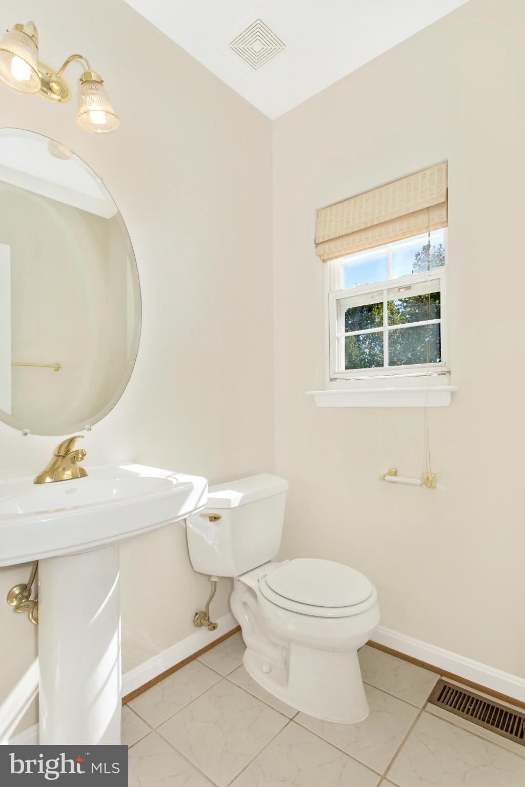 11006 Hemingway Court Silver Spring, MD 20902 - Photo 15 of 30 a white toilet sitting next to a bathroom sink