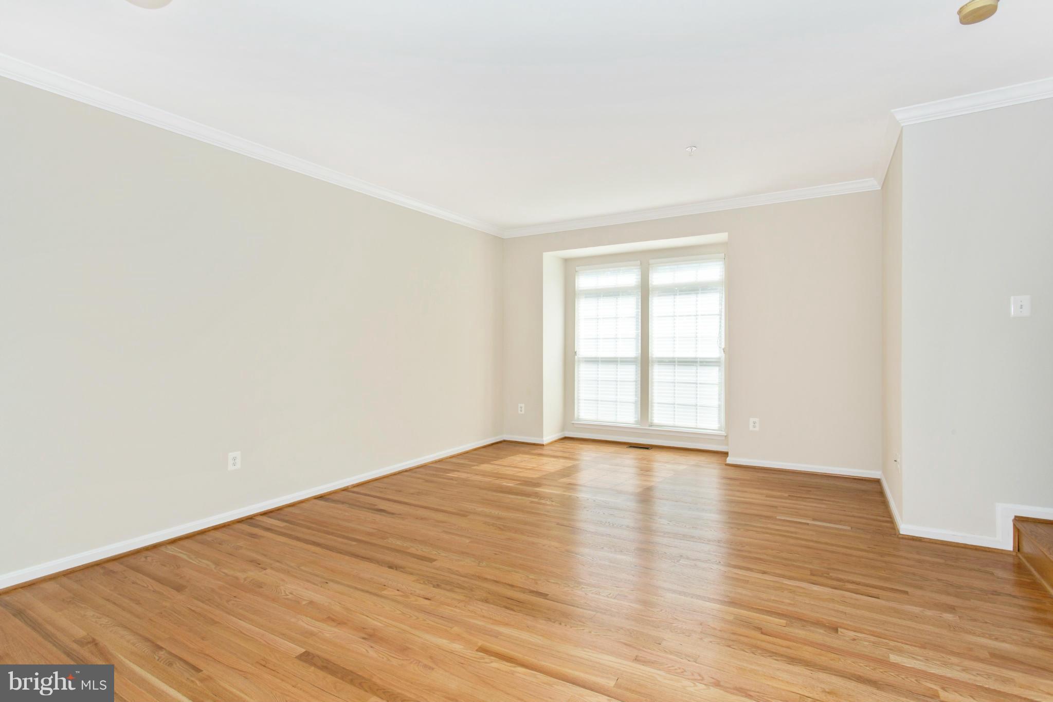 11006 Hemingway Court Silver Spring, MD 20902 - Photo 7 of 30 a view of an empty room with wooden floor and window