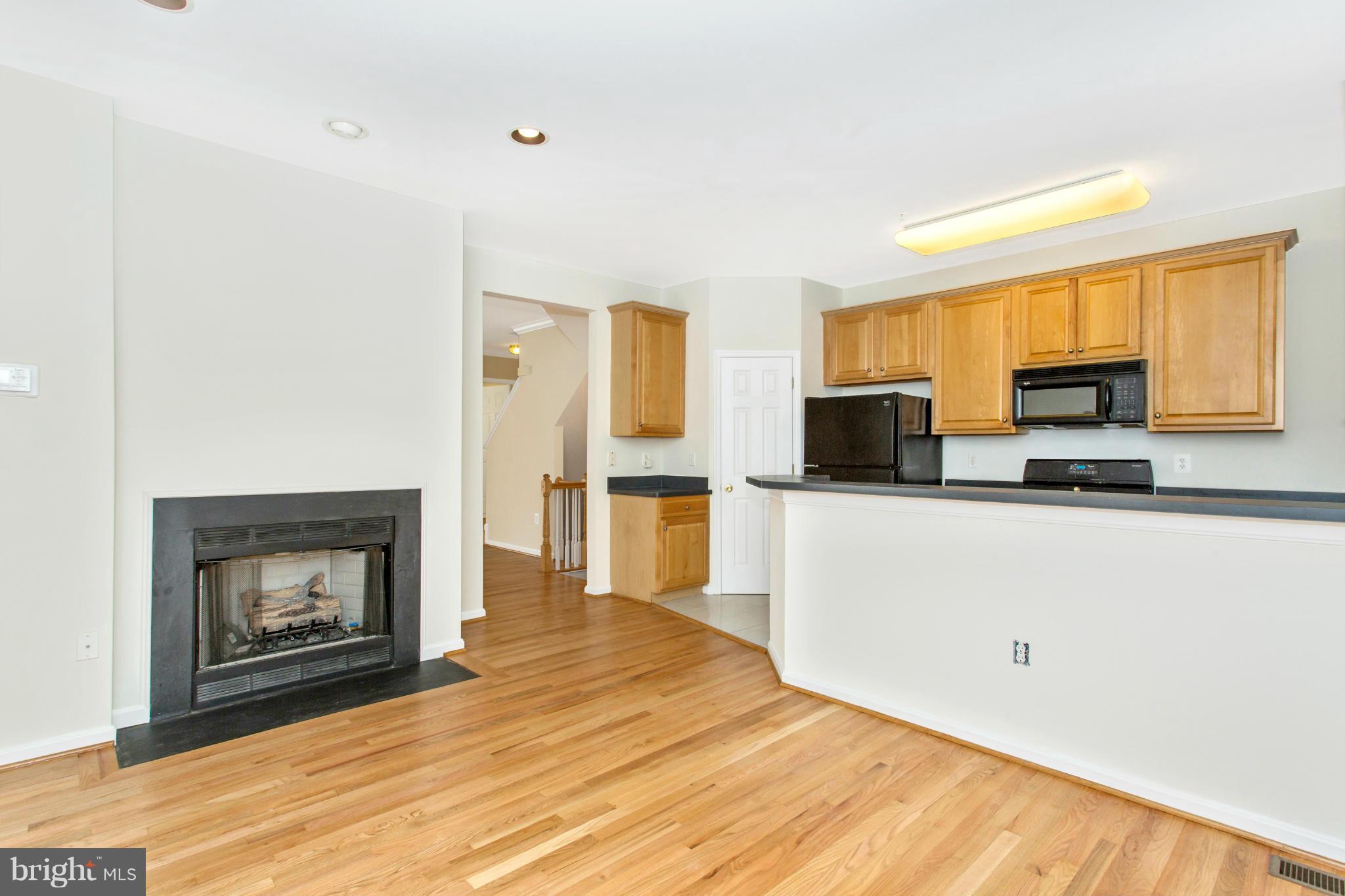 11006 Hemingway Court Silver Spring, MD 20902 - Photo 10 of 30 a living room with stainless steel appliances kitchen island a fireplace furniture a refrigerator and a fireplace