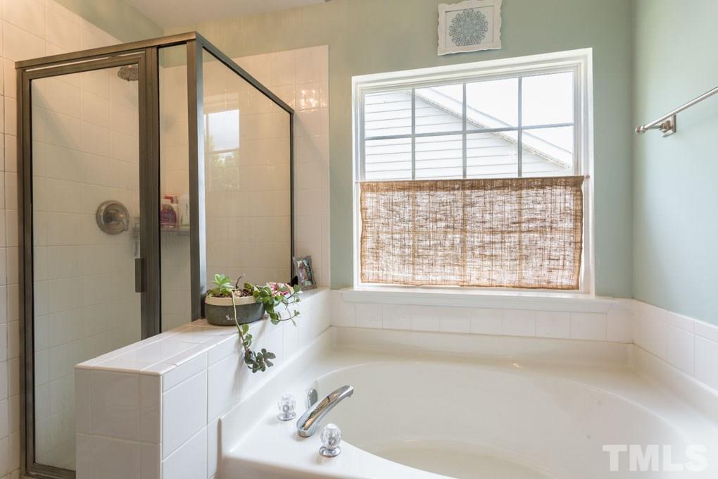 8419 Tie Stone Way Raleigh, NC 27613 - Photo 20 of 30 a bathroom with a bathtub and shower