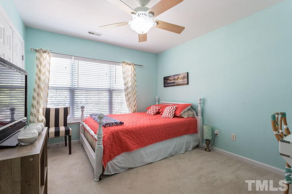 8419 Tie Stone Way Raleigh, NC 27613 - Photo 22 of 30 a bedroom with a bed and a chandelier