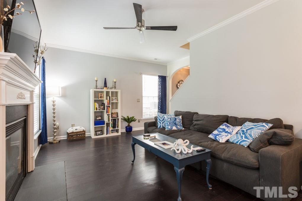 8419 Tie Stone Way Raleigh, NC 27613 - Photo 10 of 30 a living room with furniture a fireplace and a flat screen tv