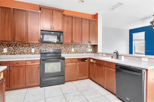 a kitchen with stainless steel appliances granite countertop a sink stove and microwave