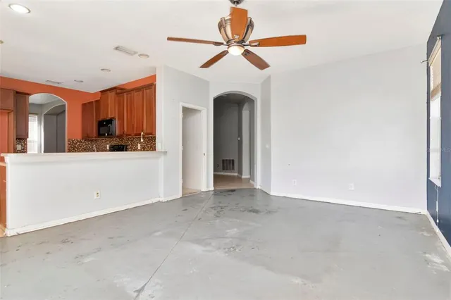 an empty room with a ceiling fan and a window