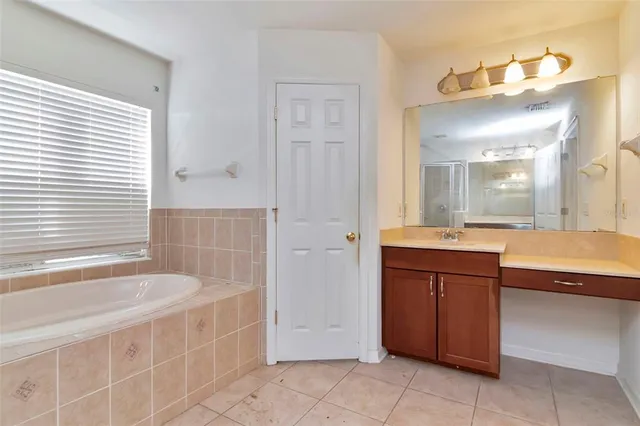 a spacious bathroom with a tub sink and mirror