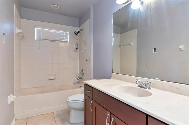 a bathroom with a granite countertop sink a toilet and shower