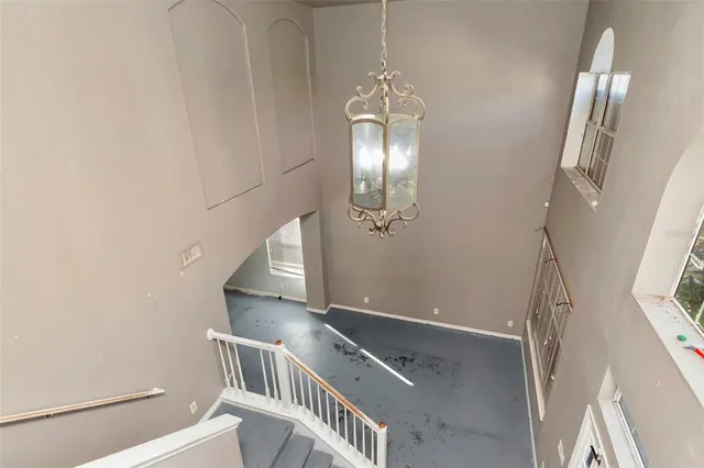 a view of staircase with railing and chandelier