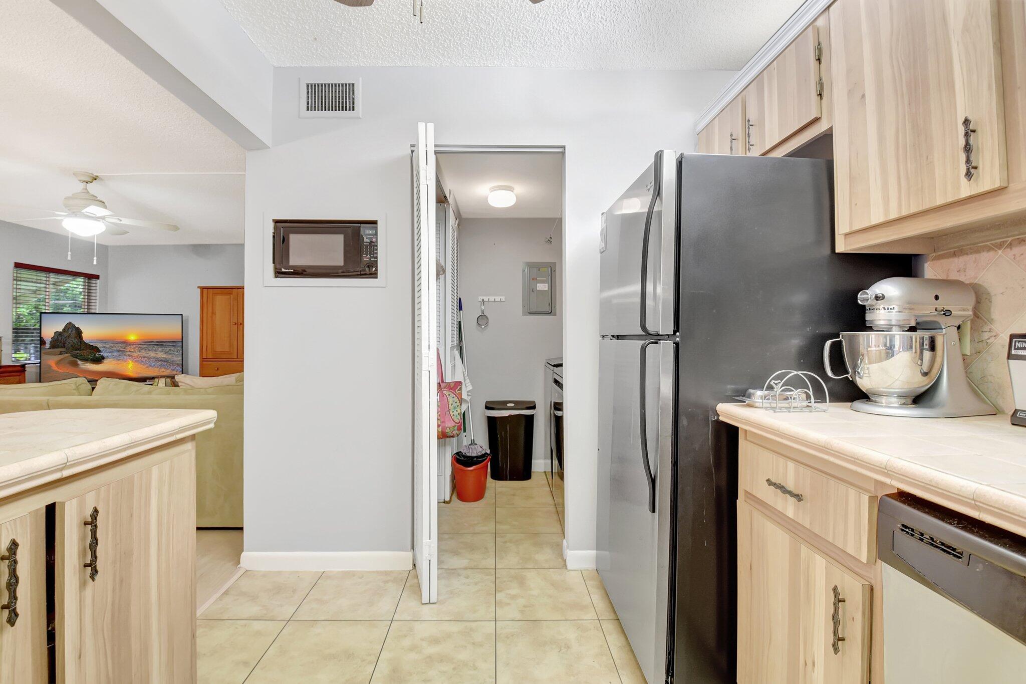 323 Pine Ridge Circle, Unit A1 Greenacres, FL 33463 - Photo 16 of 40 a kitchen with stainless steel appliances granite countertop a refrigerator and a stove