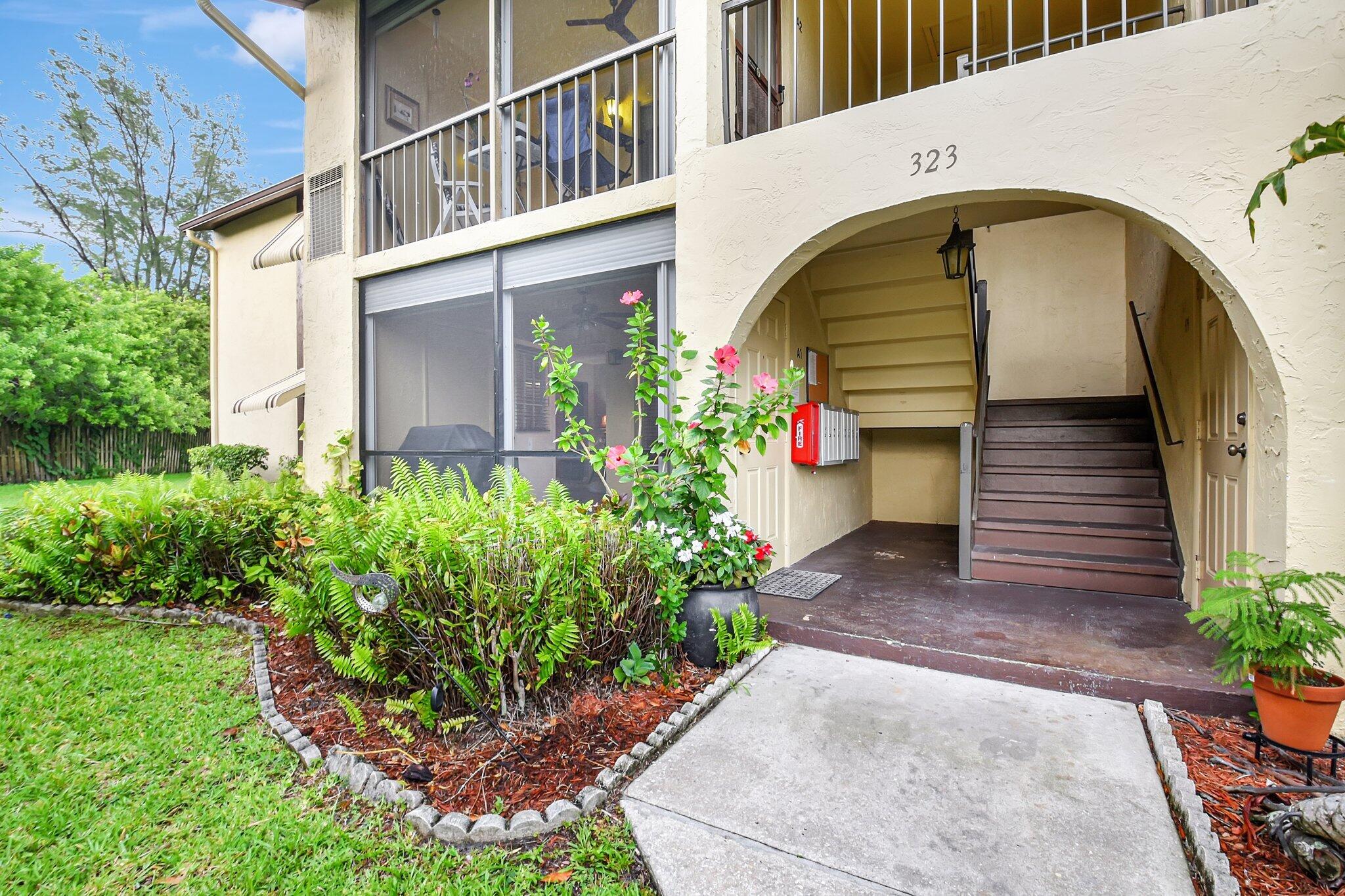323 Pine Ridge Circle, Unit A1 Greenacres, FL 33463 - Photo 2 of 40 a front view of a house with plants