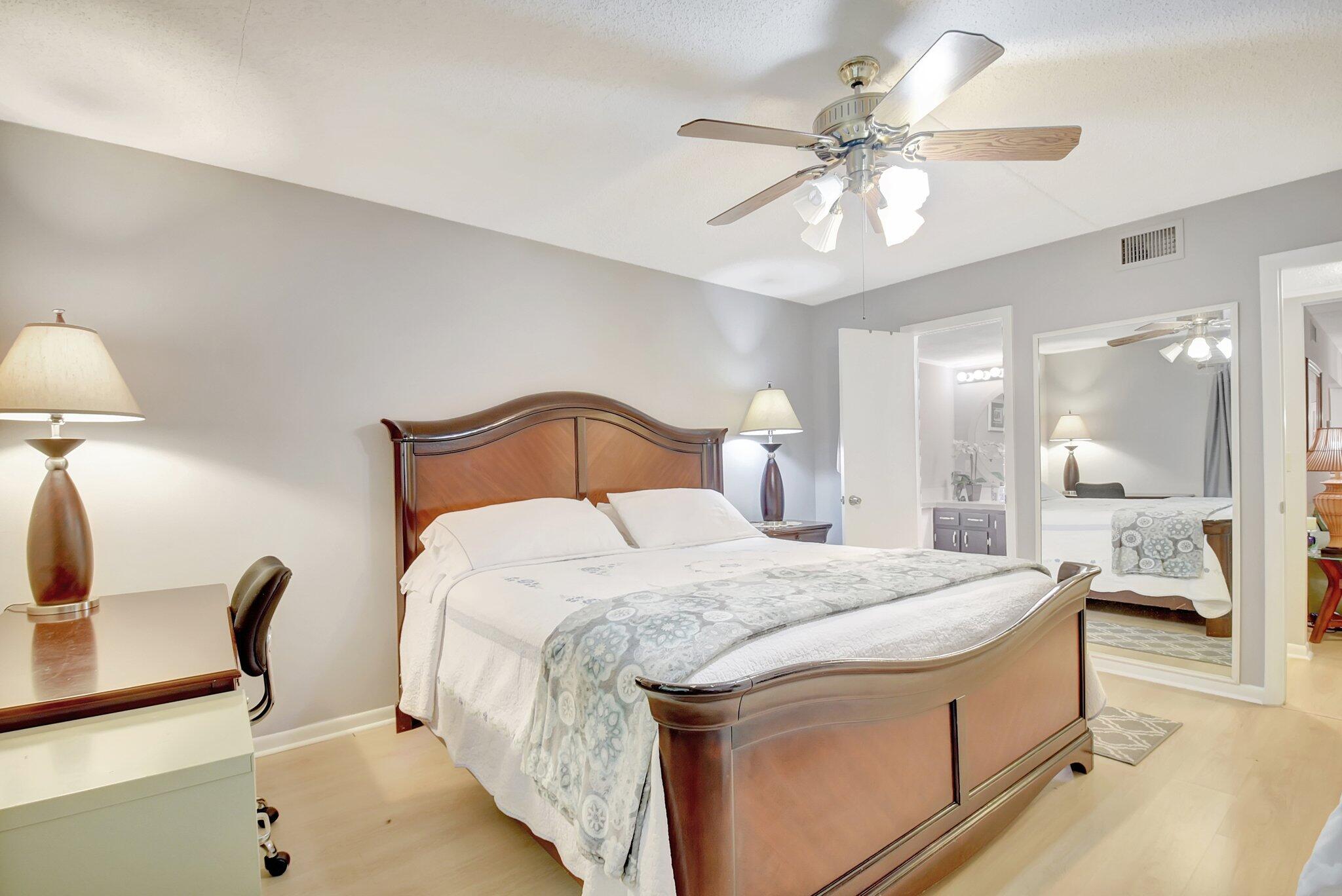 323 Pine Ridge Circle, Unit A1 Greenacres, FL 33463 - Photo 25 of 40 a bedroom with bed and a chandelier
