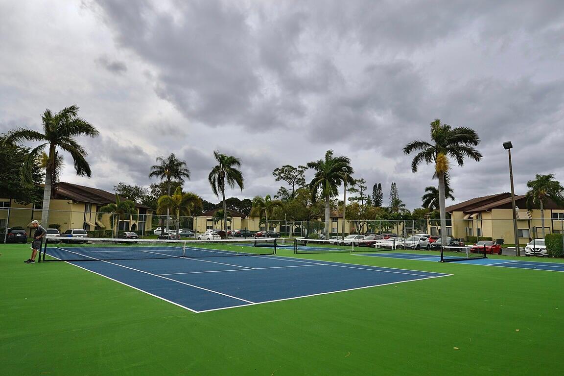 323 Pine Ridge Circle, Unit A1 Greenacres, FL 33463 - Photo 38 of 40 a palm tree sitting in front of a house with a big yard