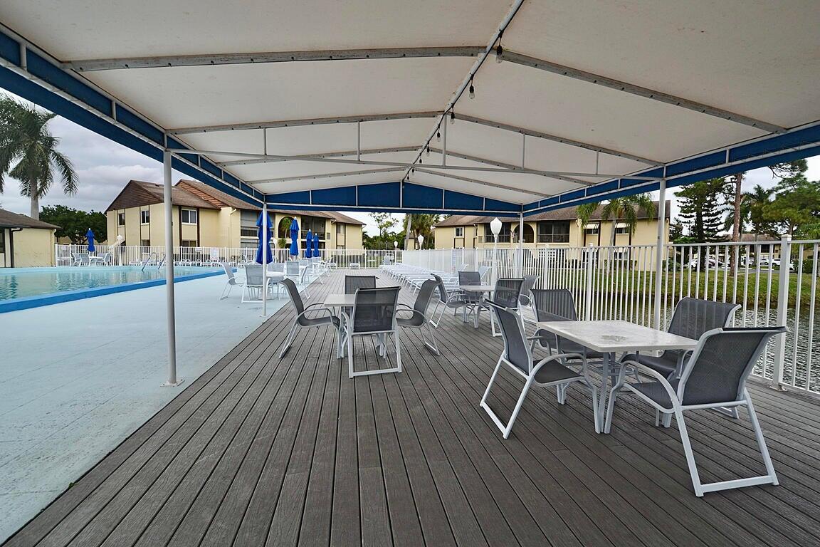 323 Pine Ridge Circle, Unit A1 Greenacres, FL 33463 - Photo 39 of 40 a view of a patio with table and chairs and wooden floor