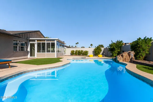 a swimming pool with outdoor seating and yard