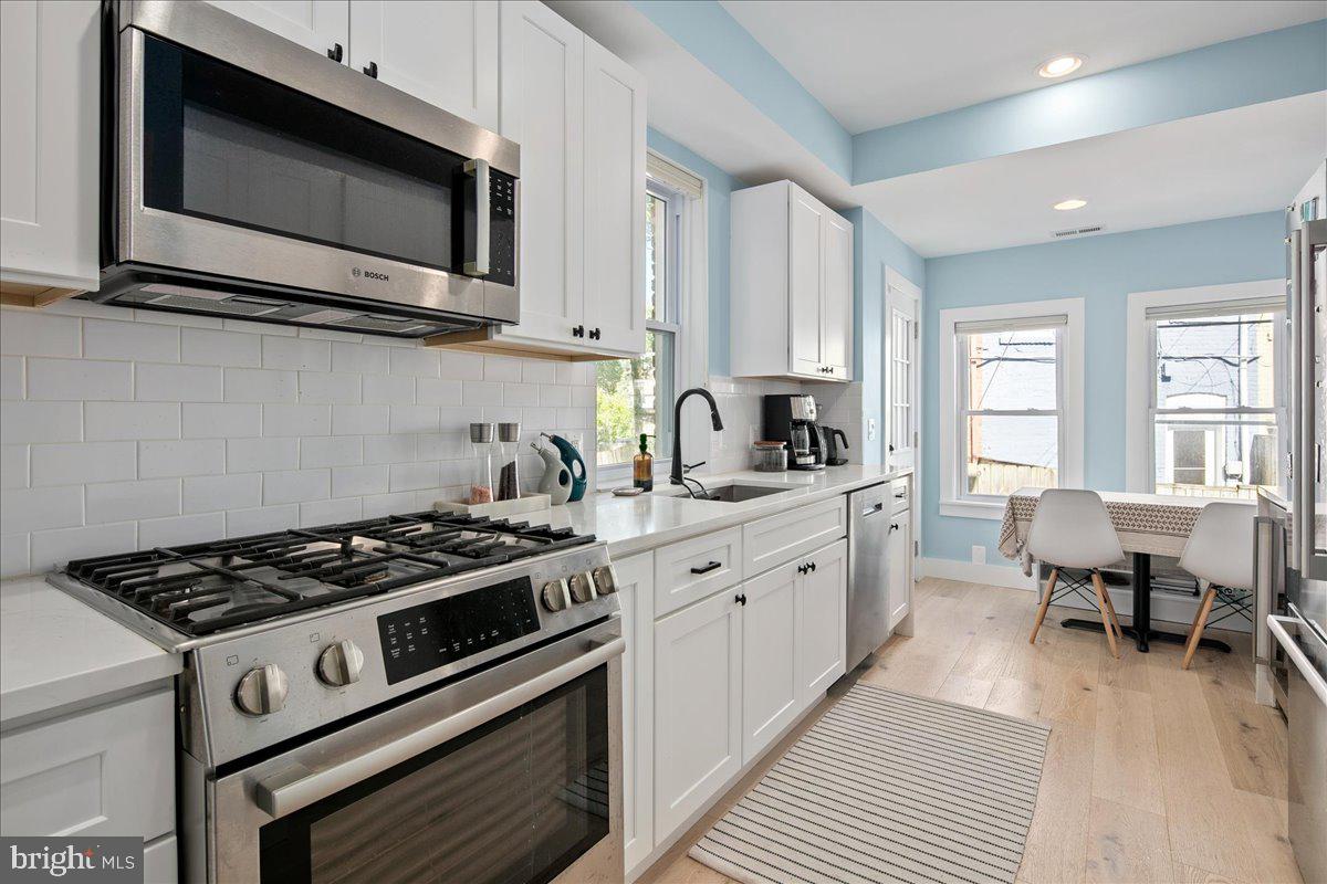 1618 G Street Southeast Washington, DC 20003 - Photo 16 of 53 a kitchen with stainless steel appliances a stove microwave and cabinets