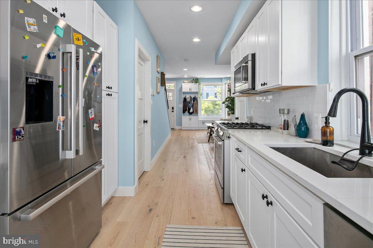 1618 G Street Southeast Washington, DC 20003 - Photo 22 of 53 a kitchen with stainless steel appliances granite countertop a refrigerator a sink dishwasher a stove and white cabinets with wooden floor