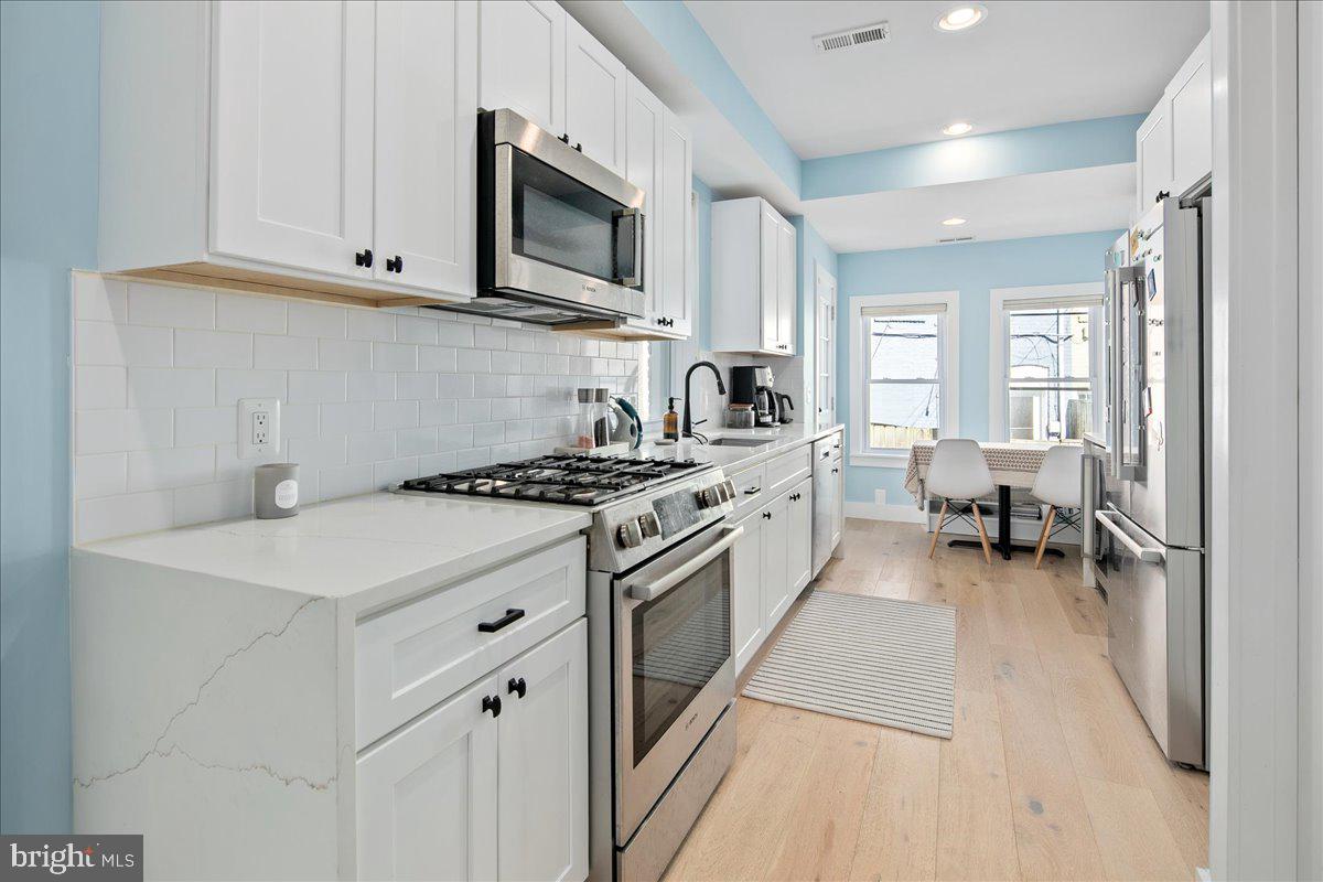 1618 G Street Southeast Washington, DC 20003 - Photo 4 of 53 a kitchen with stainless steel appliances a white stove top oven and cabinets