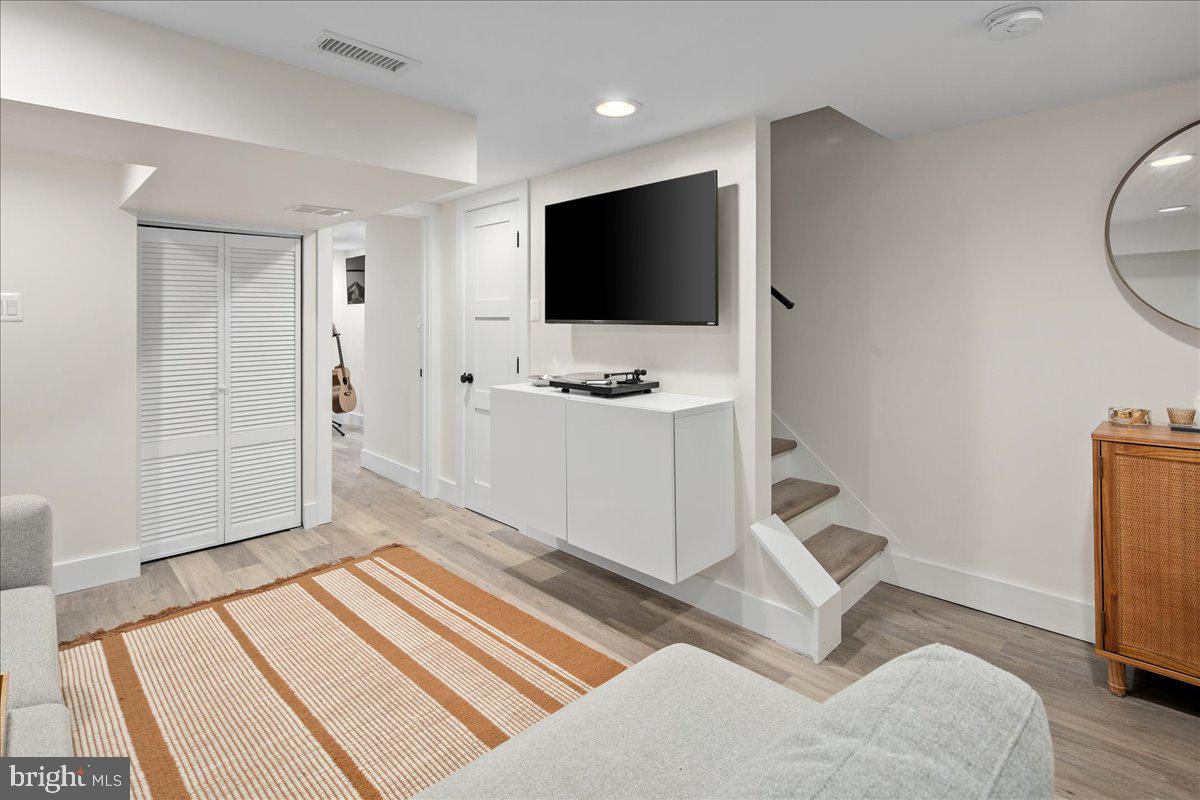 1618 G Street Southeast Washington, DC 20003 - Photo 49 of 53 a living room with a flat screen tv on dresser and a table with wooden floor