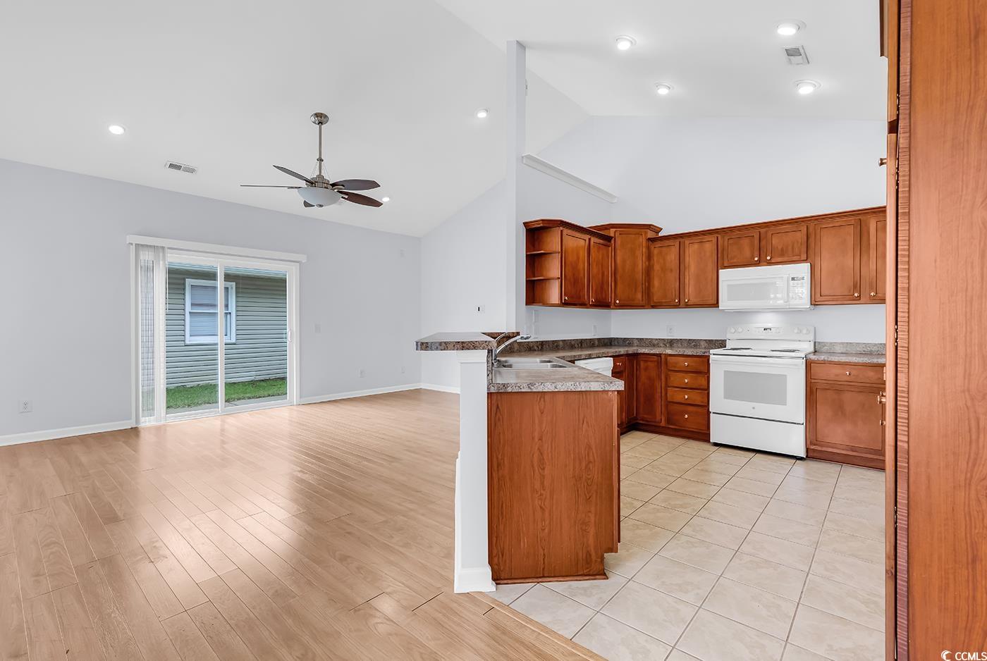 1636 Stuart Square Circle Myrtle Beach, SC 29577 - Photo 28 of 28 Kitchen with white appliances, open shelves, high vaulted ceiling, a peninsula, and open floor plan