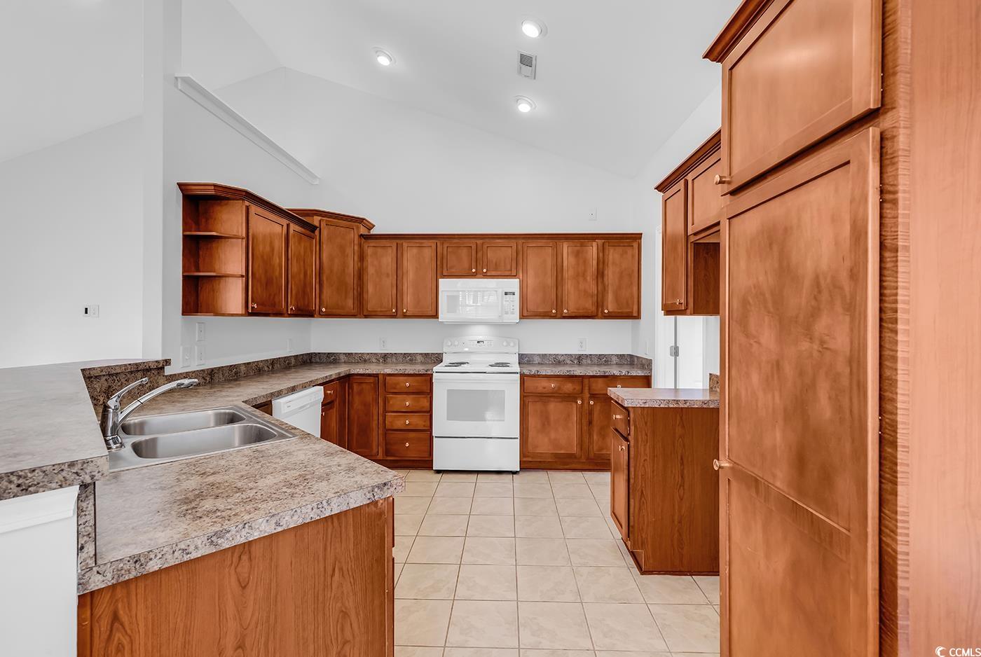 1636 Stuart Square Circle Myrtle Beach, SC 29577 - Photo 11 of 28 Kitchen with white appliances, open shelves, brown cabinetry, light tile patterned floors, and high vaulted ceiling
