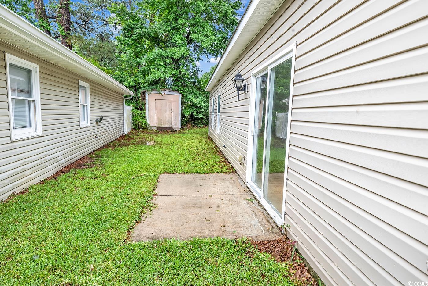 1636 Stuart Square Circle Myrtle Beach, SC 29577 - Photo 26 of 28 View of grassy yard featuring a patio area and a storage unit