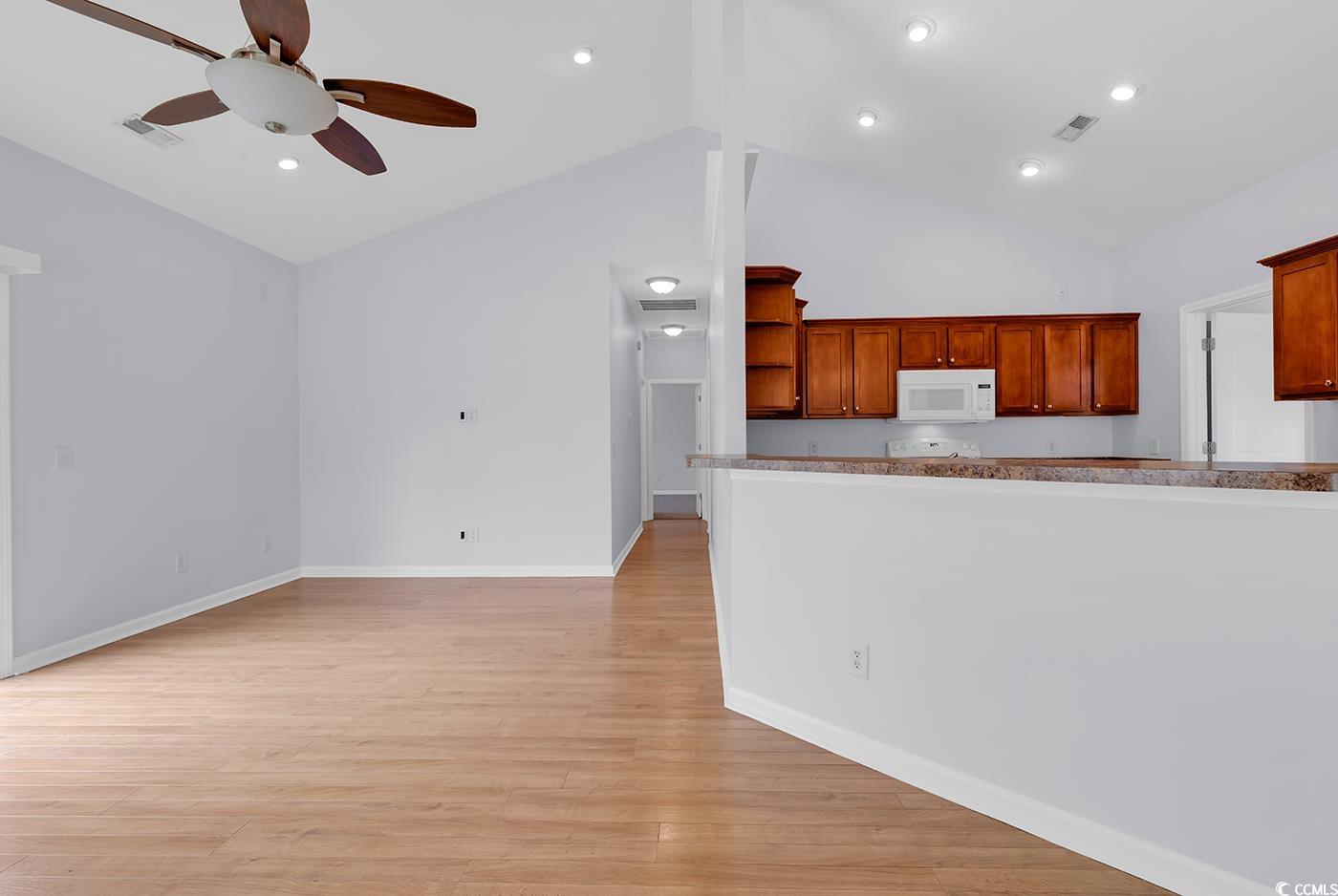 1636 Stuart Square Circle Myrtle Beach, SC 29577 - Photo 8 of 28 Kitchen featuring white microwave, ceiling fan, open shelves, light wood-style floors, and high vaulted ceiling