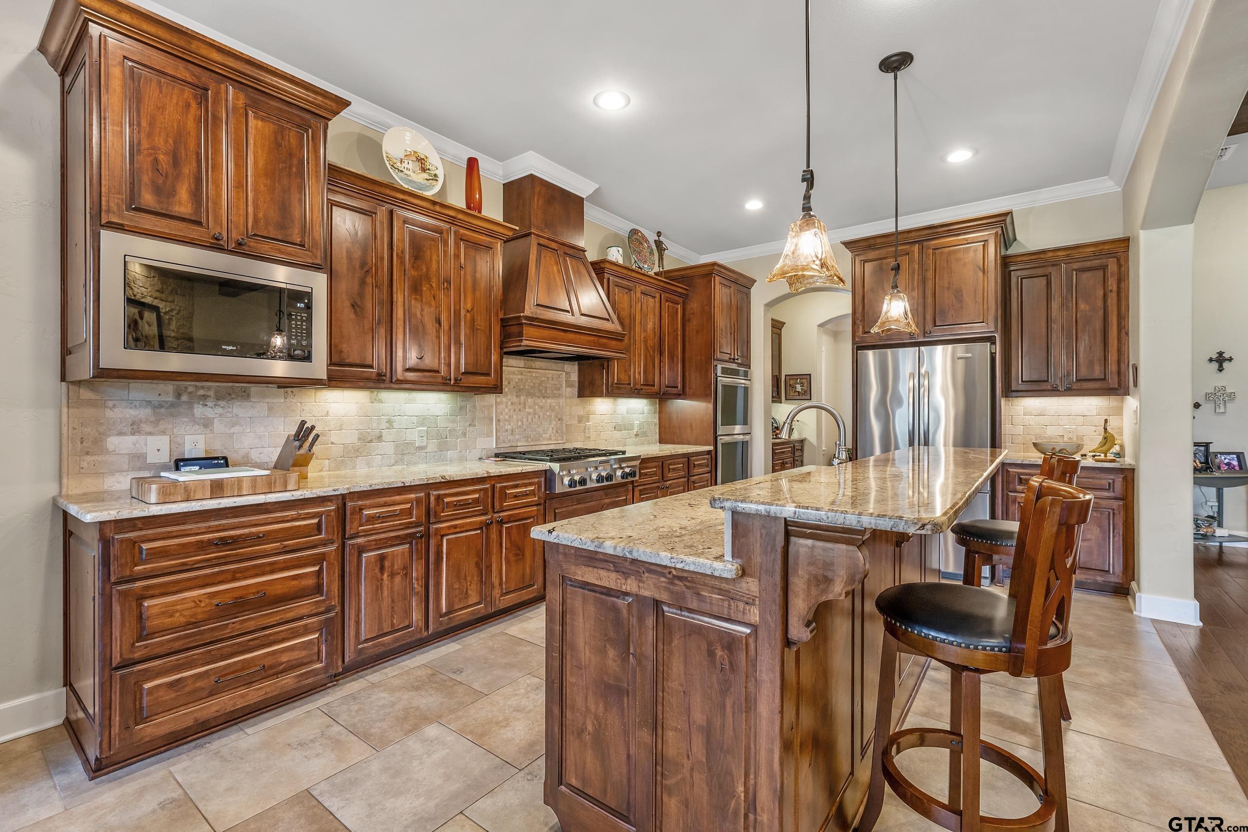 7311 Cross Road Tyler, TX 75703 - Photo 15 of 36 a kitchen with stainless steel appliances granite countertop a sink a stove a refrigerator cabinets and chairs