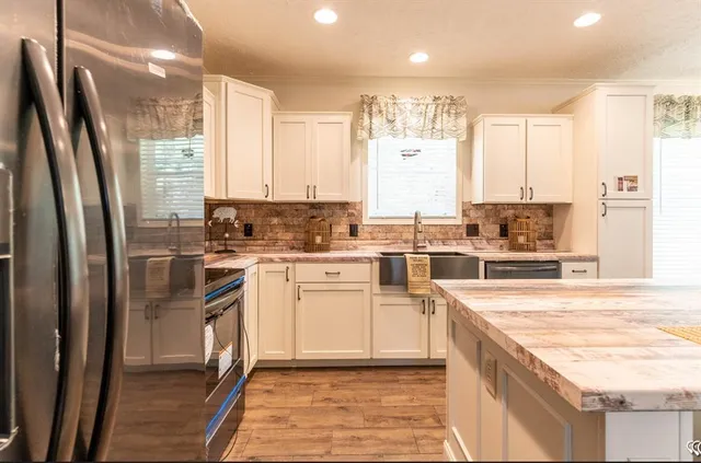 a kitchen with stainless steel appliances granite countertop a stove a sink and a refrigerator