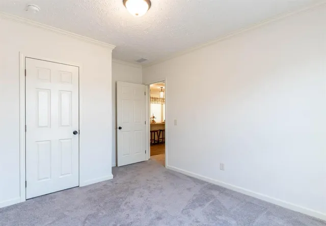 a view of an empty room with closet and a window