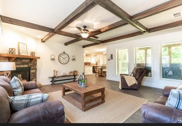 a living room with fireplace furniture and a large window