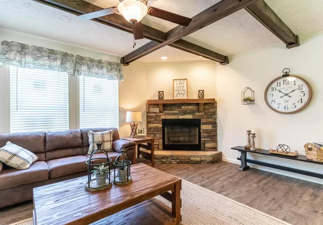 a living room with furniture a fireplace and a large window