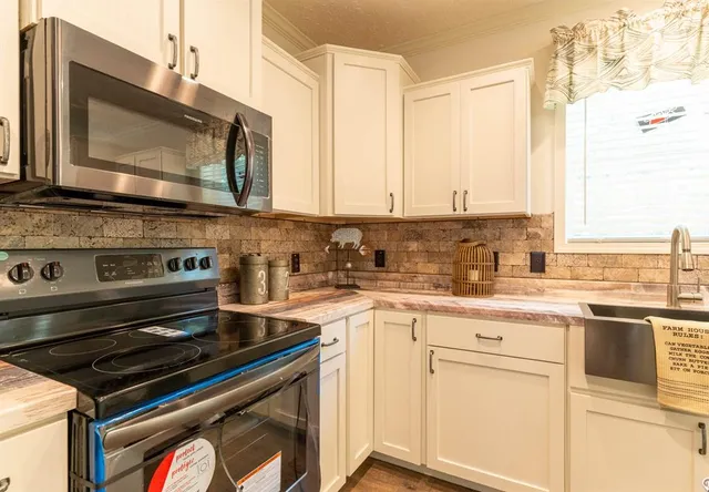 a kitchen with stainless steel appliances a stove microwave and sink