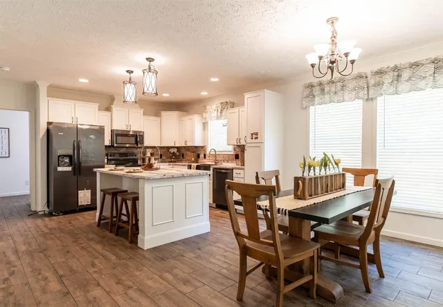 a view of a dining room with furniture and chandelier