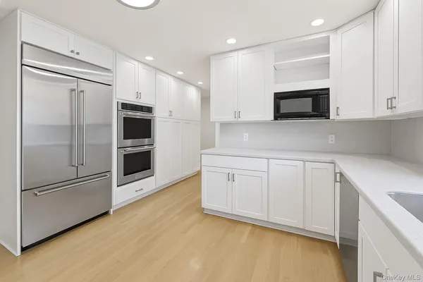 a kitchen with stainless steel appliances white cabinets and a refrigerator